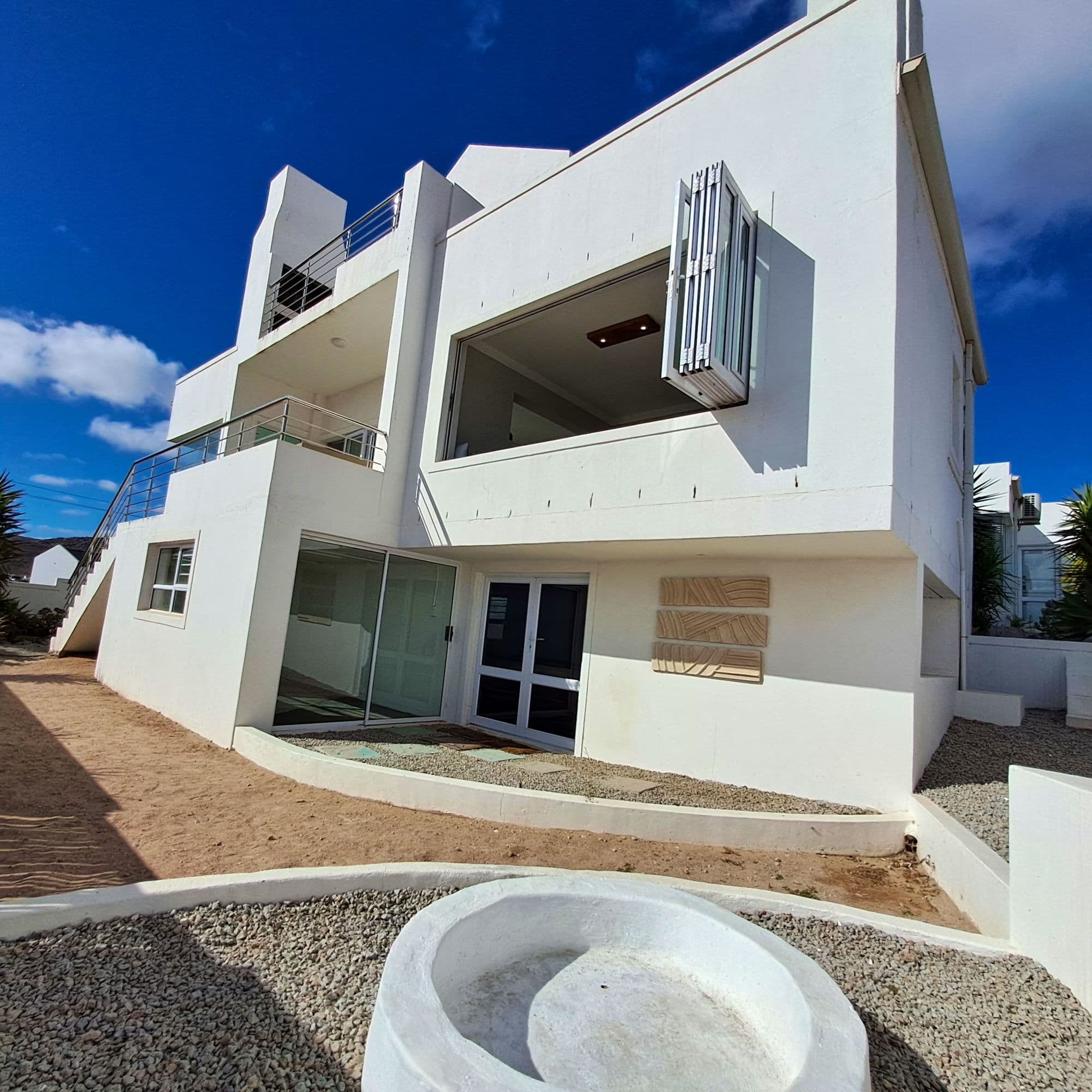 The villa's white, angular architecture against a West Coast sky