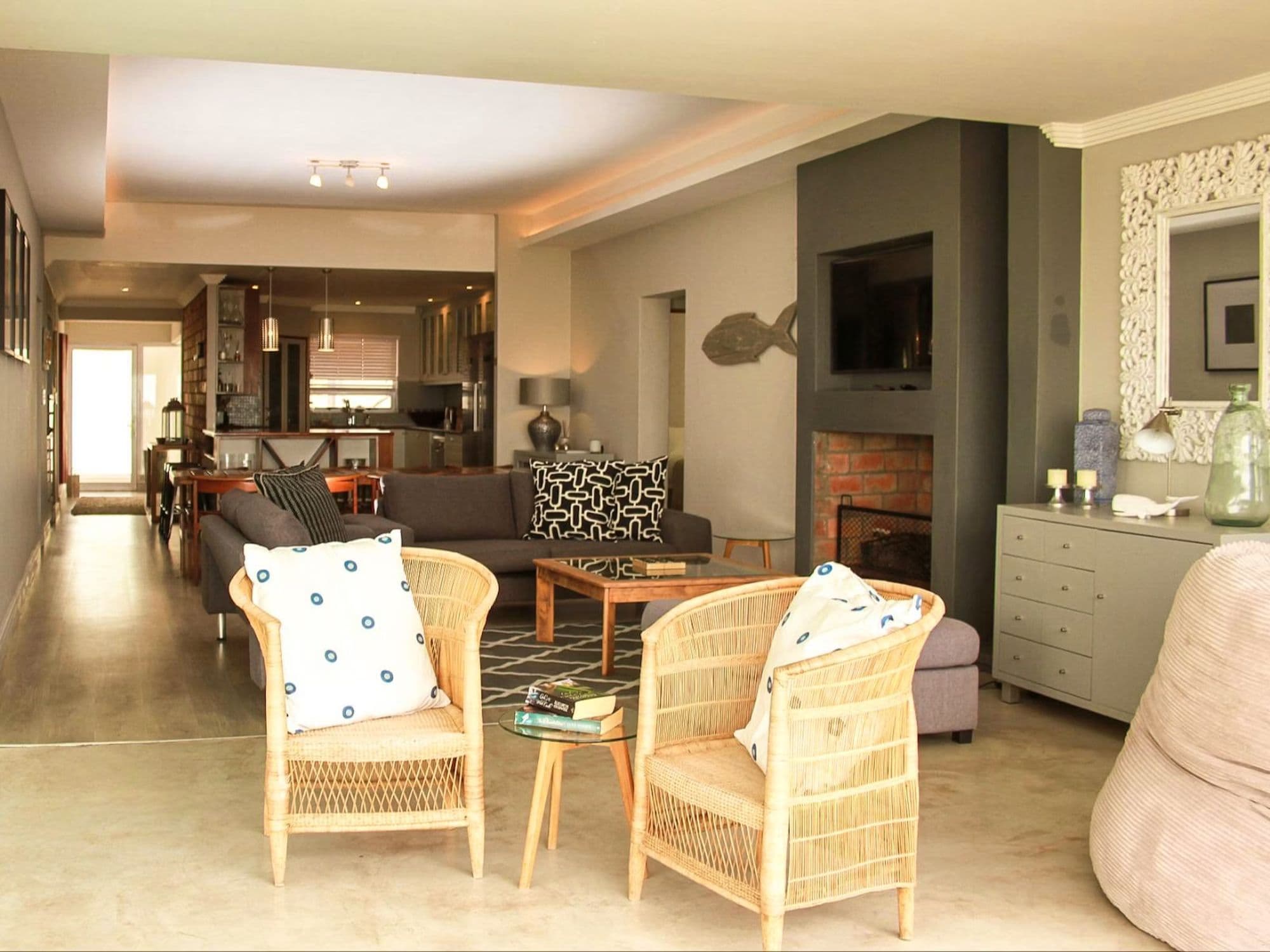A second living area with wicker chairs and a fireplace